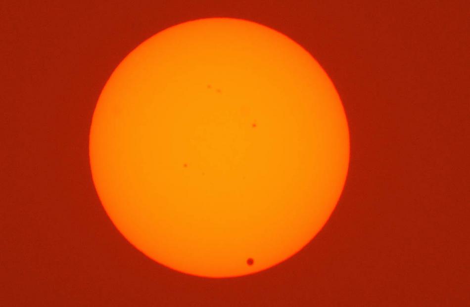 The planet Venus can be seen at bottom right at the start of its transit of the sun in this...