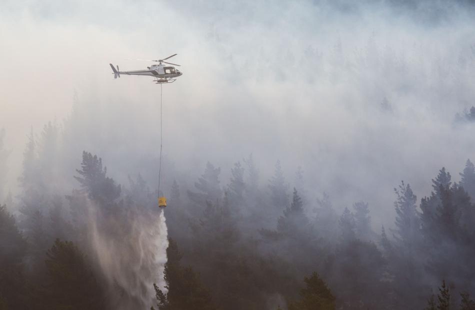 Four helicopters used monsoon buckets to fight the blaze. Photo: Andy Cole